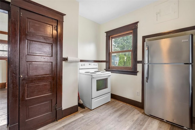 210 16th St SE, Cedar Rapids, IA 52403 - kitchen with freestanding refrigerator, white electric range oven, light wood-style floors, and dark brown cabinets