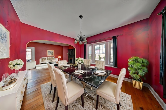 383 21st St SE, Cedar Rapids, IA 52403 - dining space with arched walkways, wood-type flooring, and a chandelier