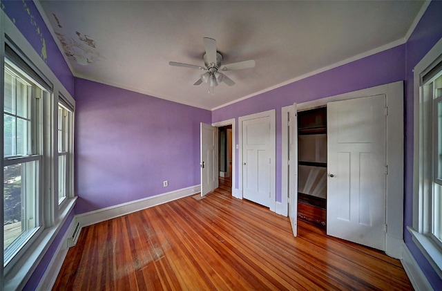 383 21st St SE, Cedar Rapids, IA 52403 - unfurnished bedroom featuring multiple windows, hardwood / wood-style floors, and a ceiling fan