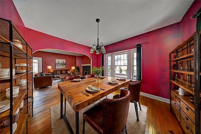 383 21st St SE, Cedar Rapids, IA 52403 - dining space featuring arched walkways, wood-type flooring, and a chandelier