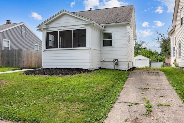 609 34th St NE, Cedar Rapids, IA 52402 - view of front of property with a shingled roof, a sunroom, a garage, and an outdoor structure