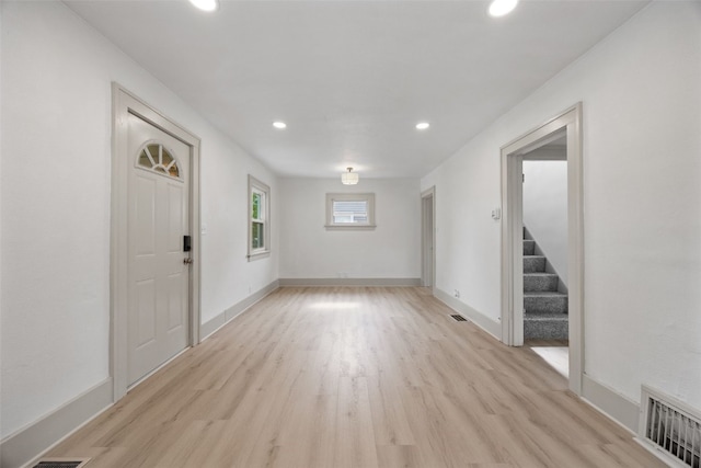 609 34th St NE, Cedar Rapids, IA 52402 - unfurnished living room featuring light wood-style flooring, recessed lighting, and stairs