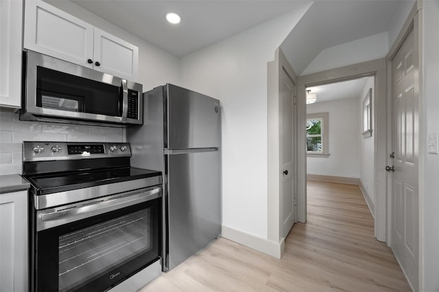 609 34th St NE, Cedar Rapids, IA 52402 - kitchen with appliances with stainless steel finishes, white cabinets, light wood-type flooring, backsplash, and recessed lighting
