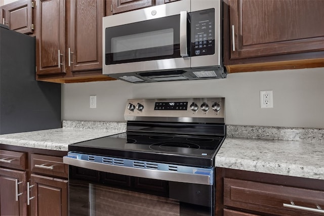265 Parkview Ct, North Liberty, IA 52317 - kitchen with appliances with stainless steel finishes, light countertops, and dark brown cabinetry