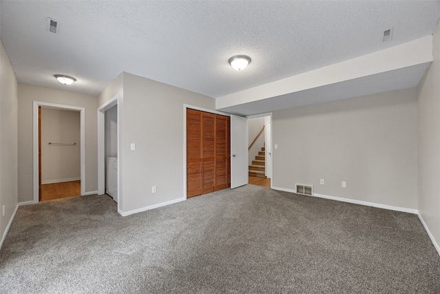 265 Parkview Ct, North Liberty, IA 52317 - unfurnished bedroom featuring carpet flooring, a closet, and a textured ceiling