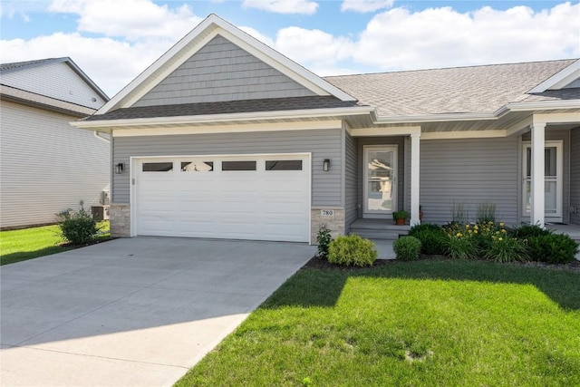 780 Brook Ridge Ave, North Liberty, IA 52317 - view of front of home with a front lawn, a garage, driveway, roof with shingles, and stone siding