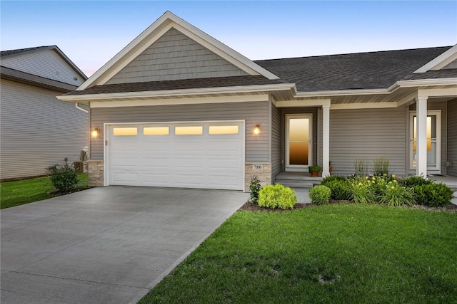 780 Brook Ridge Ave, North Liberty, IA 52317 - craftsman-style house with a front lawn, driveway, an attached garage, roof with shingles, and stone siding