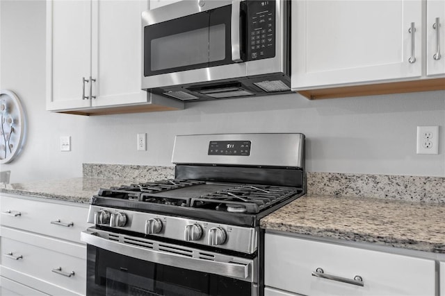 780 Brook Ridge Ave, North Liberty, IA 52317 - kitchen featuring stainless steel appliances, white cabinets, and light stone counters