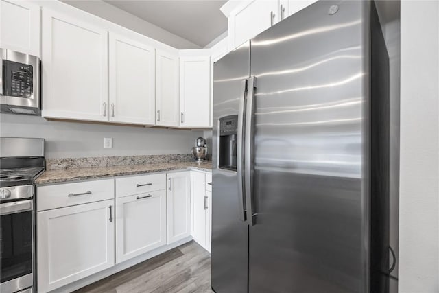 780 Brook Ridge Ave, North Liberty, IA 52317 - kitchen with appliances with stainless steel finishes, white cabinetry, wood finished floors, and light stone countertops