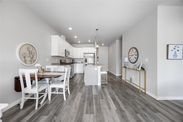 780 Brook Ridge Ave, North Liberty, IA 52317 - kitchen with stainless steel appliances, vaulted ceiling, dark wood-style floors, a center island with sink, and a breakfast bar