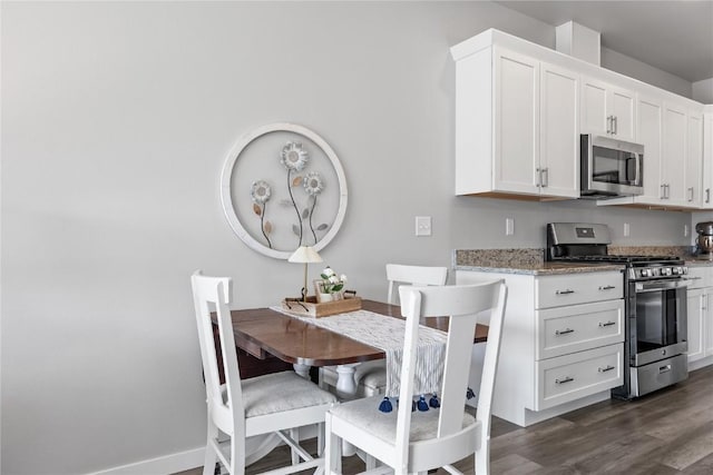 780 Brook Ridge Ave, North Liberty, IA 52317 - kitchen featuring stainless steel appliances, dark wood finished floors, white cabinetry, and light stone counters