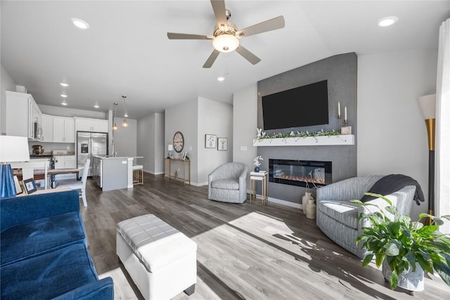 780 Brook Ridge Ave, North Liberty, IA 52317 - living area featuring a glass covered fireplace, ceiling fan, wood finished floors, recessed lighting, and vaulted ceiling
