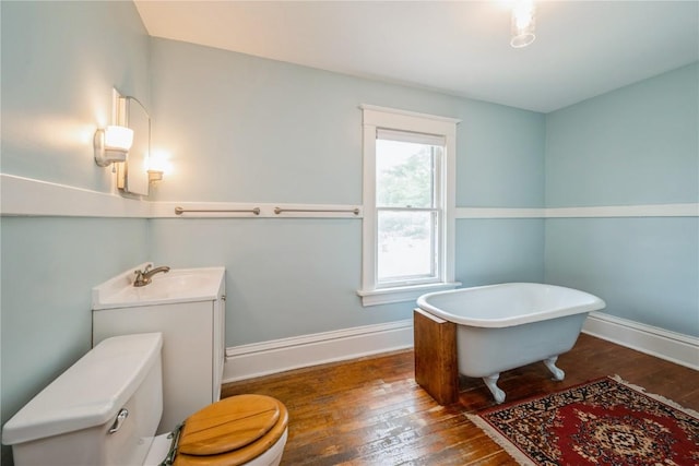 1022 19th St SE, Cedar Rapids, IA 52403 - bathroom with a freestanding tub, wood-type flooring, and vanity