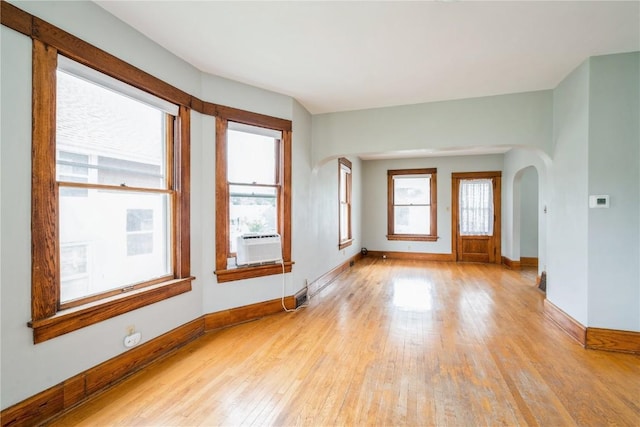 1022 19th St SE, Cedar Rapids, IA 52403 - unfurnished room featuring arched walkways, light wood-type flooring, and plenty of natural light