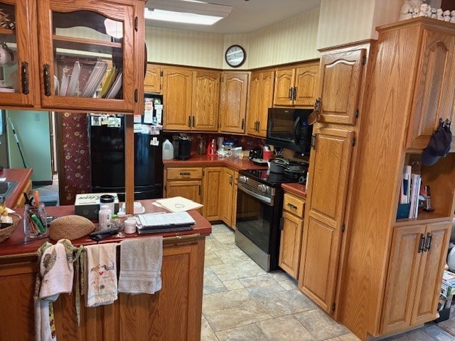 2119 Lakeview Ridge Dr NE, Solon, IA 52333 - kitchen featuring black appliances, brown cabinets, light stone finish flooring, wallpapered walls, and glass insert cabinets