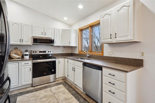 2135 Lake View Ridge Dr NE, Solon, IA 52333 - kitchen featuring stainless steel appliances, dark countertops, vaulted ceiling, white cabinets, and recessed lighting