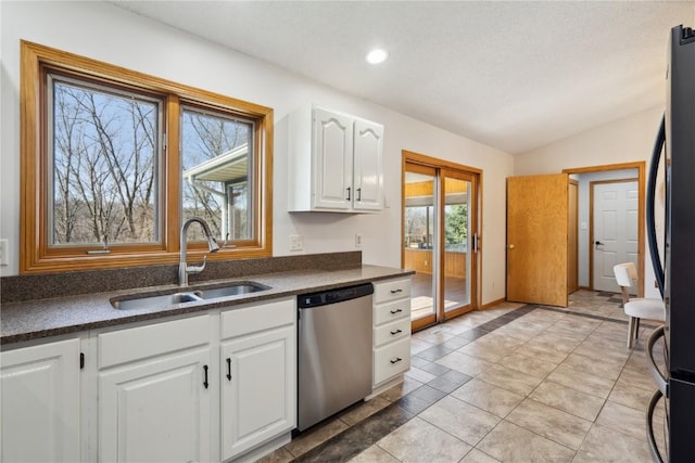 2135 Lake View Ridge Dr NE, Solon, IA 52333 - kitchen featuring stainless steel dishwasher, dark countertops, white cabinetry, lofted ceiling, and freestanding refrigerator