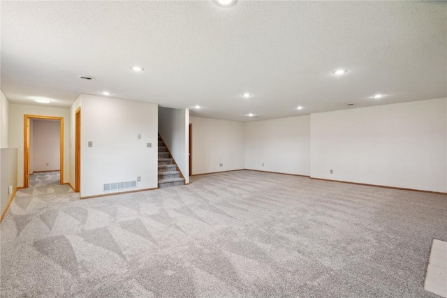2135 Lake View Ridge Dr NE, Solon, IA 52333 - empty room featuring stairs, light colored carpet, recessed lighting, and a textured ceiling