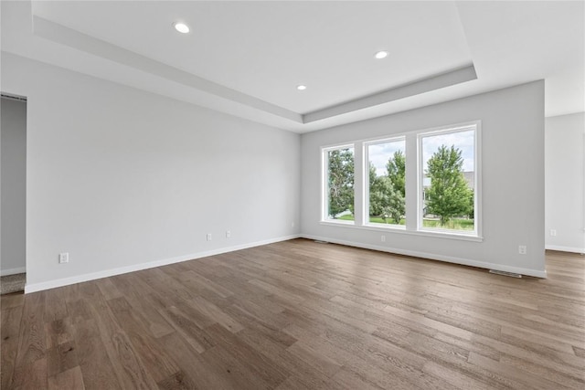 226 Mccarran Ave NE, Cedar Rapids, IA 52402 - empty room with a tray ceiling, wood finished floors, and recessed lighting