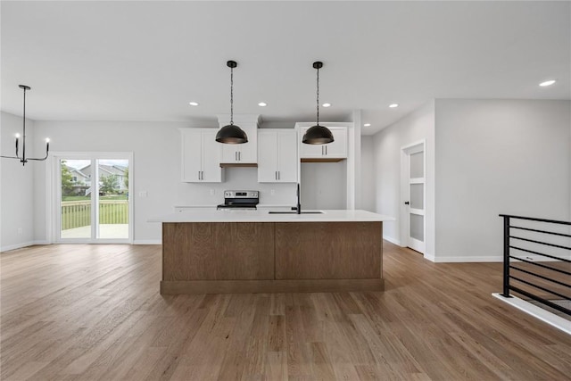 226 Mccarran Ave NE, Cedar Rapids, IA 52402 - kitchen with stainless steel electric range oven, light wood-style floors, white cabinets, a large island with sink, and recessed lighting