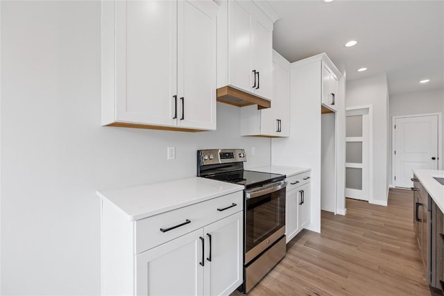 226 Mccarran Ave NE, Cedar Rapids, IA 52402 - kitchen with electric range, light countertops, light wood-style flooring, white cabinetry, and recessed lighting