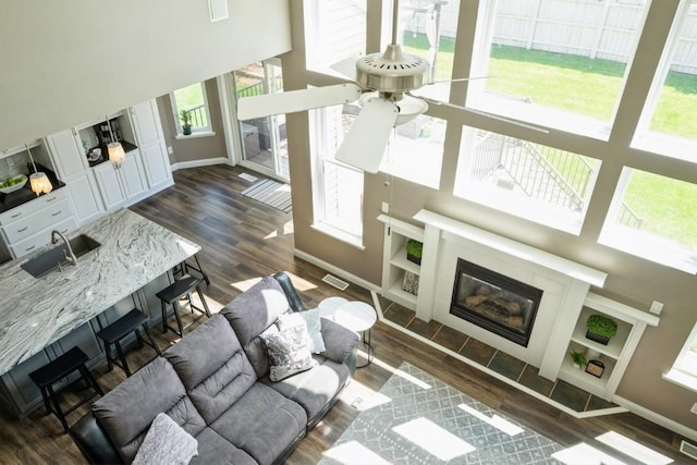 2654 Mulberry Ct, Marion, IA 52302 - living area with wood finished floors, a towering ceiling, a glass covered fireplace, and a ceiling fan