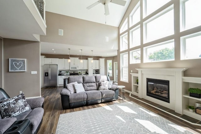 2654 Mulberry Ct, Marion, IA 52302 - living room featuring a high ceiling, dark wood-style floors, ceiling fan, and a glass covered fireplace