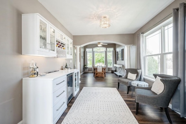 2654 Mulberry Ct, Marion, IA 52302 - kitchen with arched walkways, dark wood-style flooring, wine cooler, glass insert cabinets, and light countertops