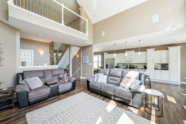 2654 Mulberry Ct, Marion, IA 52302 - living area featuring dark wood-style flooring, high vaulted ceiling, stairway, and ceiling fan