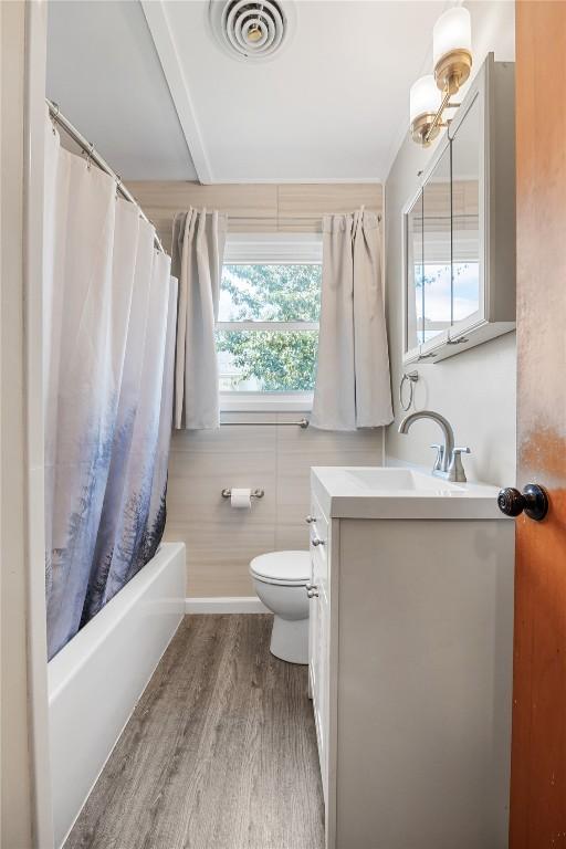 1140 31st St, Cedar Rapids, IA 52402 - bathroom with vanity, wood finished floors, and shower / tub combo