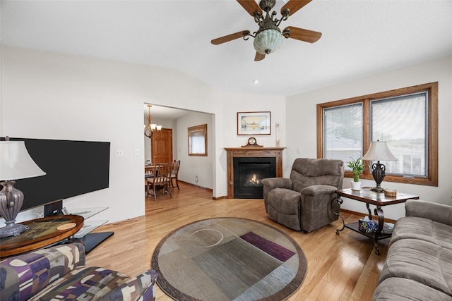 906 29th St NW, Cedar Rapids, IA 52405 - living area with light wood-type flooring, a lit fireplace, a ceiling fan, and a chandelier