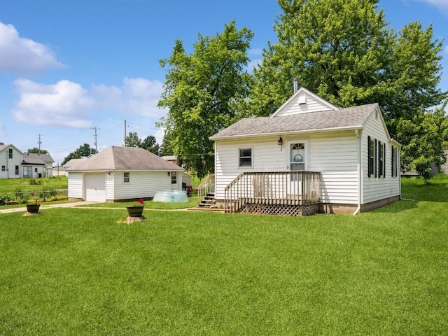 1 E Jefferson Ave S, Urbana, IA 52345 - rear view of property featuring a garage, a lawn, an outbuilding, and roof with shingles