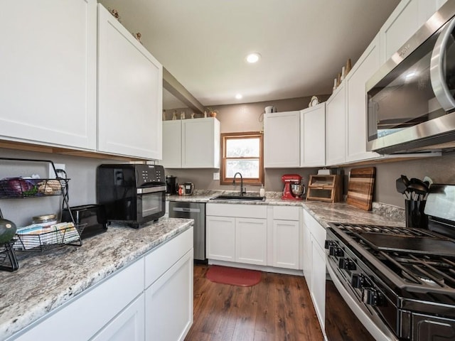 1 E Jefferson Ave S, Urbana, IA 52345 - kitchen with stainless steel appliances, dark wood-style floors, white cabinets, light stone countertops, and recessed lighting