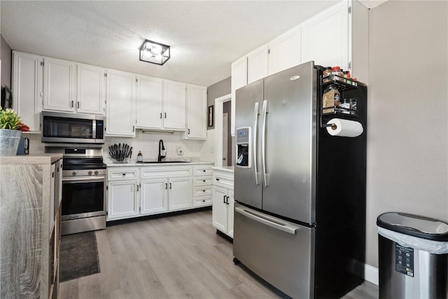 3140 Stratford Ln SW, Cedar Rapids, IA 52404 - kitchen with stainless steel appliances, white cabinetry, light countertops, and wood finished floors
