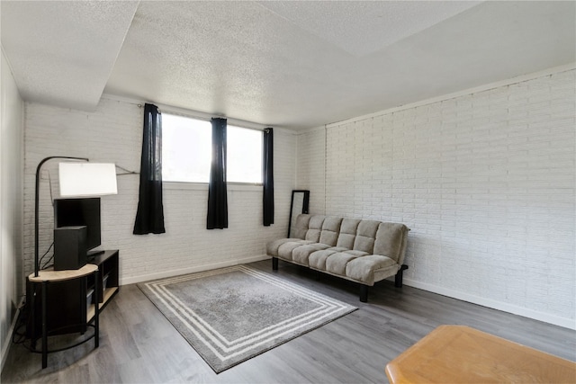 3140 Stratford Ln SW, Cedar Rapids, IA 52404 - living room with brick wall, wood finished floors, and a textured ceiling
