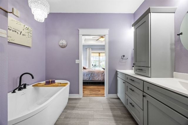 605 Alexis Ln, Marion, IA 52302 - ensuite bathroom featuring vanity, a freestanding tub, wood finished floors, a ceiling fan, and a chandelier