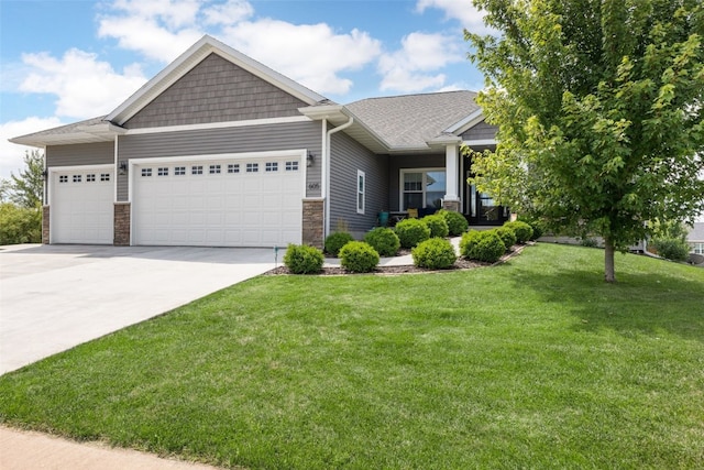 605 Alexis Ln, Marion, IA 52302 - craftsman house featuring a garage, concrete driveway, a front lawn, stone siding, and a shingled roof
