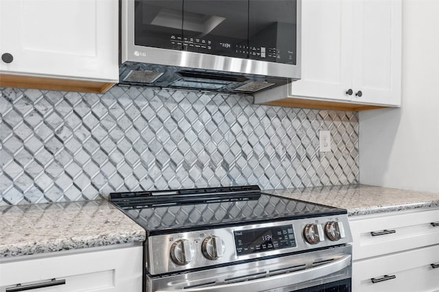 605 Alexis Ln, Marion, IA 52302 - kitchen featuring appliances with stainless steel finishes, backsplash, white cabinets, and light stone counters