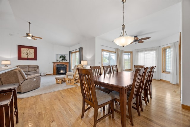 6845 Flint Rock Ct, Marion, IA 52302 - dining area featuring a ceiling fan, a glass covered fireplace, light wood finished floors, and vaulted ceiling