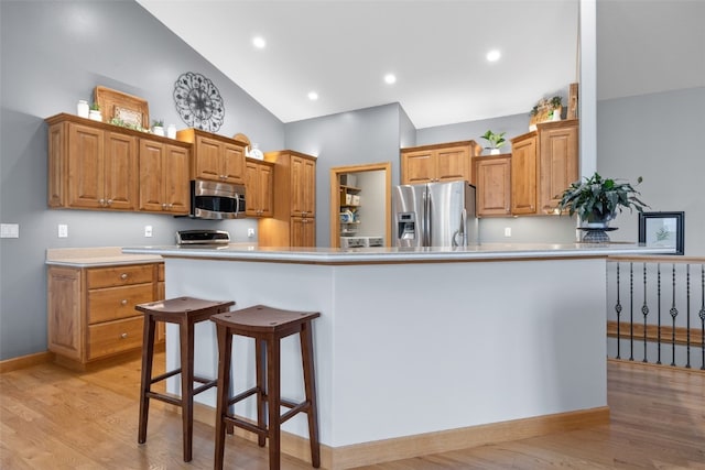 6845 Flint Rock Ct, Marion, IA 52302 - kitchen featuring appliances with stainless steel finishes, high vaulted ceiling, light wood-type flooring, light countertops, and brown cabinetry