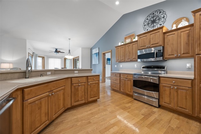 6845 Flint Rock Ct, Marion, IA 52302 - kitchen featuring stainless steel appliances, lofted ceiling, brown cabinets, and light wood-type flooring