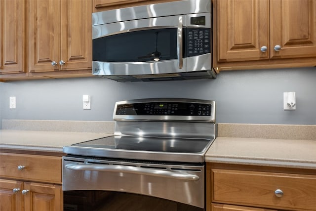 6845 Flint Rock Ct, Marion, IA 52302 - kitchen featuring stainless steel appliances, light countertops, and brown cabinets