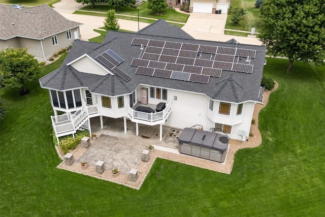 6845 Flint Rock Ct, Marion, IA 52302 - back of house featuring a shingled roof, solar panels, a patio area, a sunroom, and a lawn