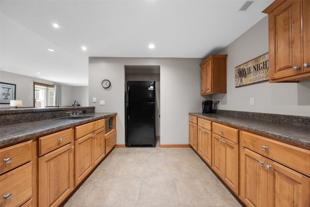 6845 Flint Rock Ct, Marion, IA 52302 - kitchen with freestanding refrigerator, dark countertops, recessed lighting, and brown cabinetry