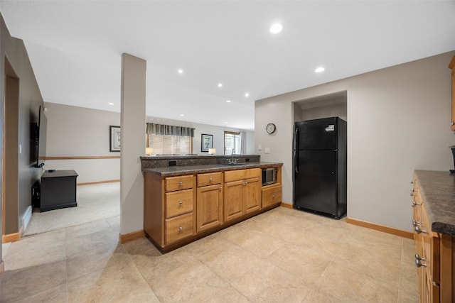 6845 Flint Rock Ct, Marion, IA 52302 - kitchen with freestanding refrigerator, dark countertops, stainless steel microwave, brown cabinetry, and recessed lighting