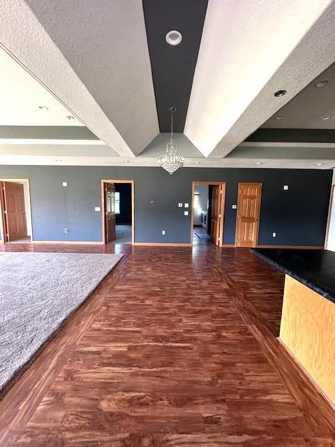832 E Main St, Central City, IA 52214 - spare room with a raised ceiling, a chandelier, and wood finished floors