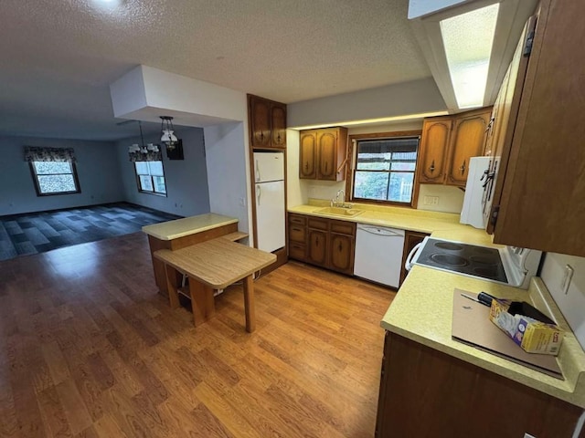 1852 215th St, Manchester, IA 52057 - kitchen featuring white appliances, light countertops, light wood-style floors, a textured ceiling, and plenty of natural light