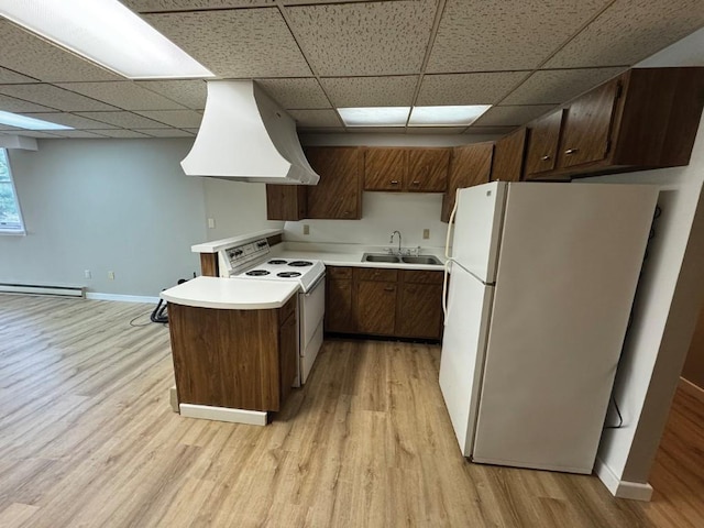 1852 215th St, Manchester, IA 52057 - kitchen featuring white appliances, premium range hood, a paneled ceiling, a baseboard heating unit, and light wood-style flooring