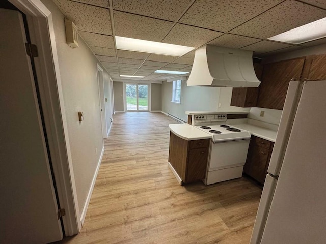1852 215th St, Manchester, IA 52057 - kitchen with white appliances, premium range hood, a drop ceiling, light wood-style floors, and light countertops