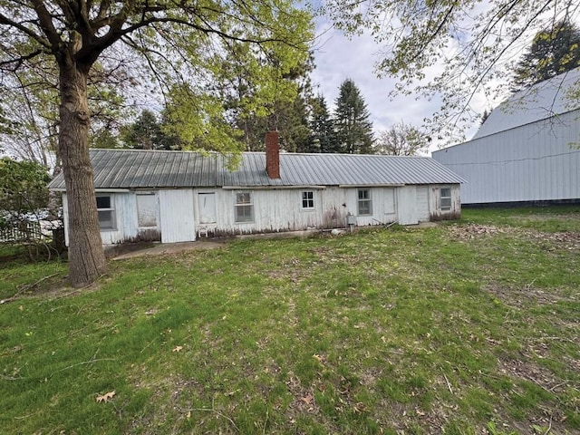 1852 215th St, Manchester, IA 52057 - rear view of house featuring a chimney, a metal roof, and a yard